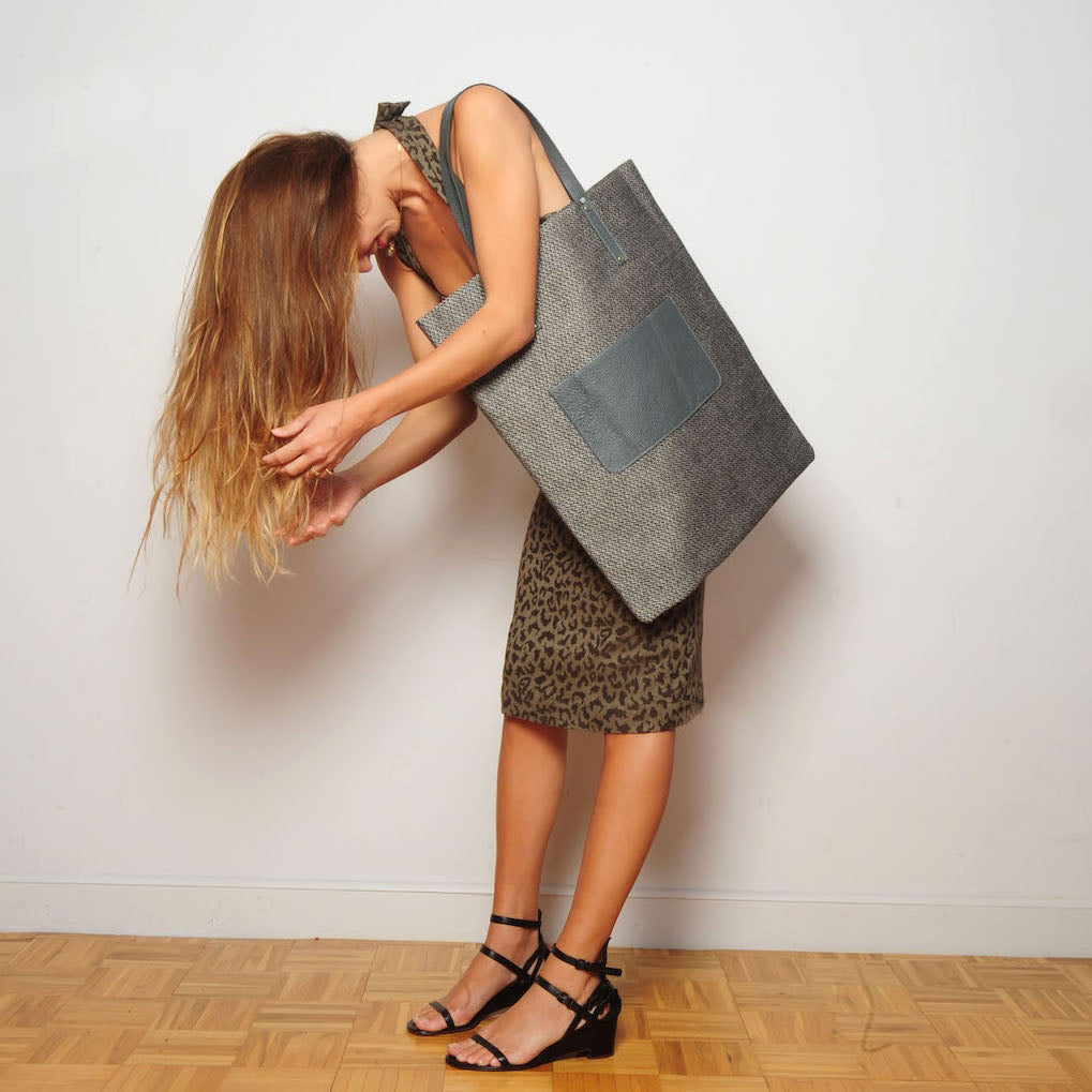 HIGH BAG #27 EVA ZINGONI | Tweed | Nous sommes argent graphique  https://www.evazingoni.fr/products/copie-de-high-bag-6-soie-fleurs-vertes-nous-sommes-or-graphique  Sac cabas luxe en tweed de laine gris et cuir gris. Citation philosophique en coloris argent "Nous sommes des êtres spirituels vivant une expérience humaine." de Pierre Teilhard de Chardin. Eco-friendly tote bag. Tweed tote bag